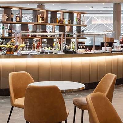 Area lounge aeroportuale con bar e tavoli - Lounge