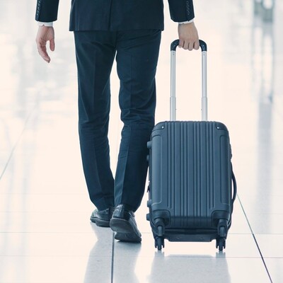 Passeggero che trasporta una valigia in aeroporto - Porta bagagli